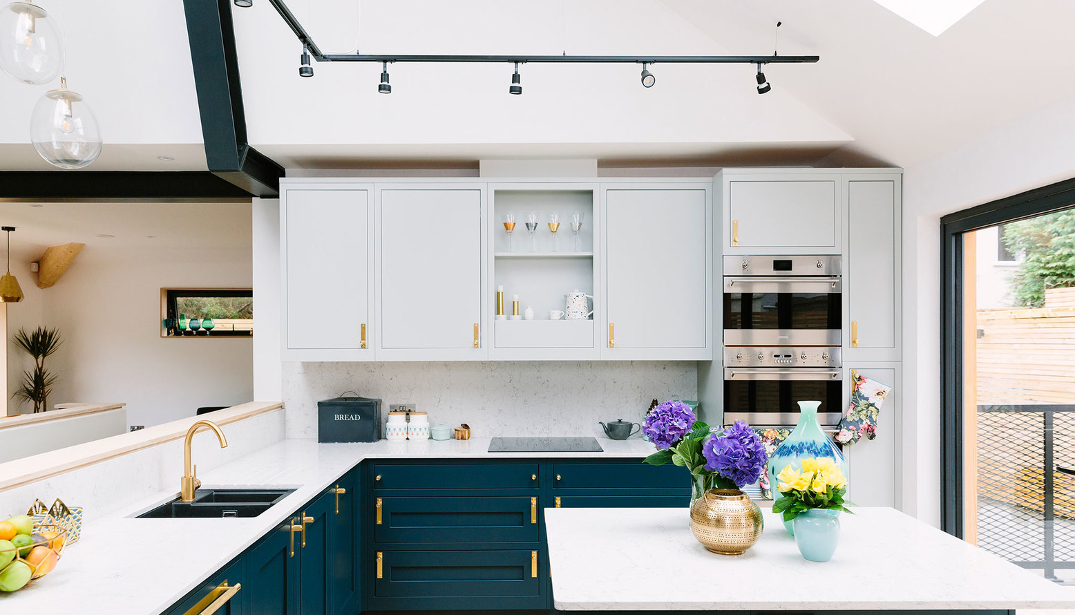 Marble worktops and blue cabinets and brass handles and knobs for an affordable but expensive looking kitchen 