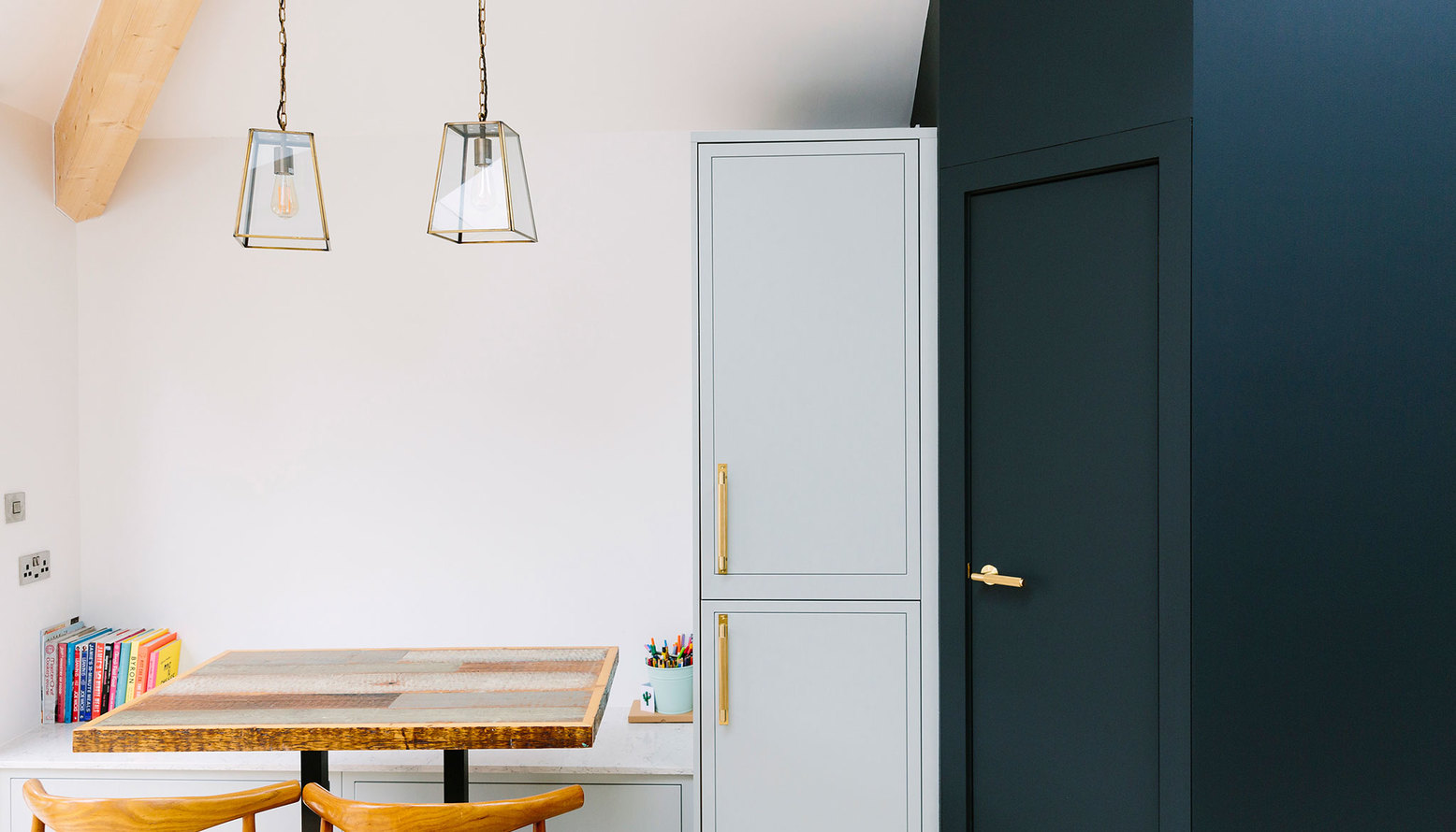 Bespoke dining bench seating with Pooky pendants and dark blue feature paint 