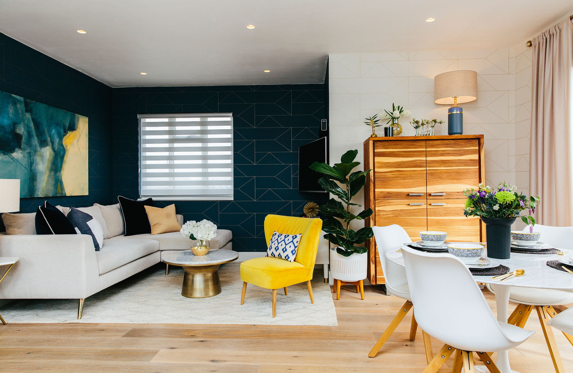 Geometric pattern wallpaper with pattern clashing pillows and cream sofa